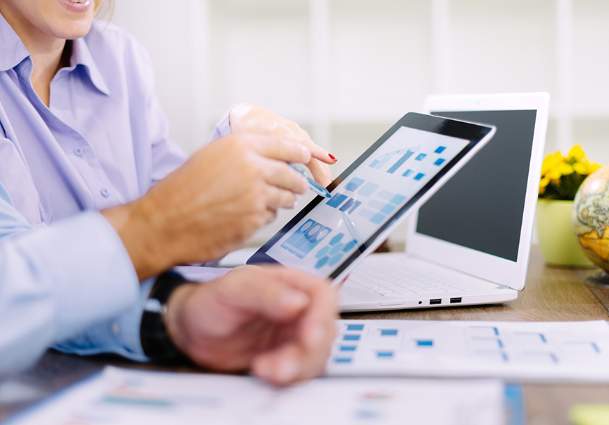 A man and woman looking at a tablet