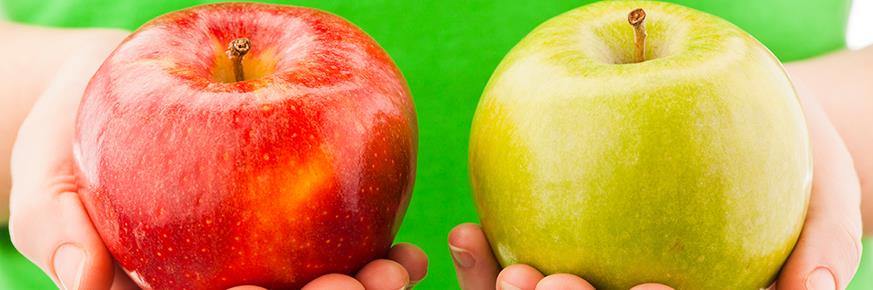 A hand holding a red apple and a hand holding a green apple