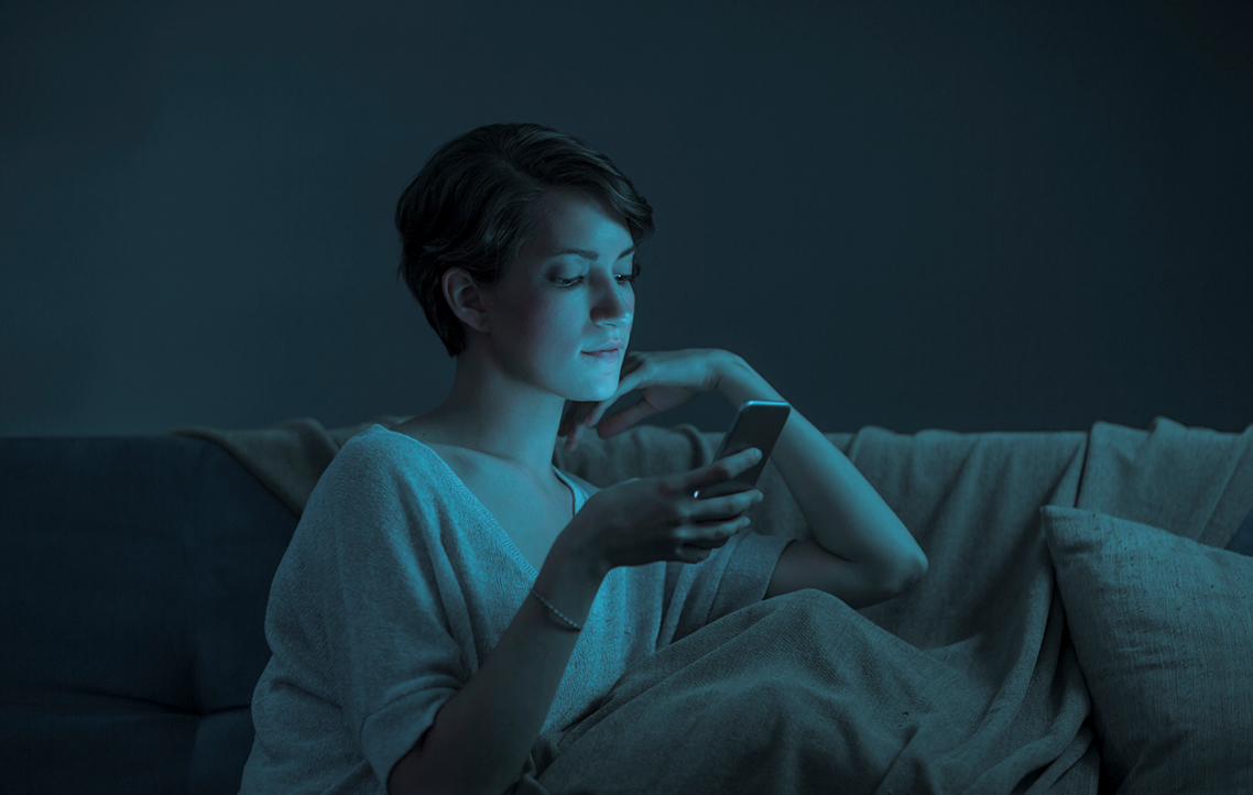 A woman holding a smartphone during an outage