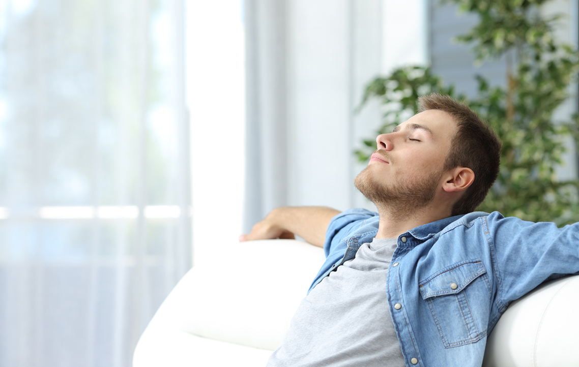 A relaxed man reclining on the couch