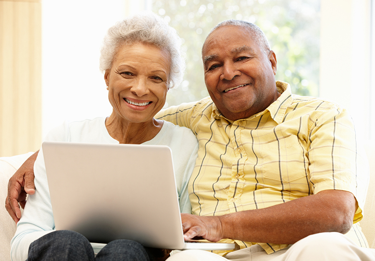 Elderly couple set up automatic bill pay online through their laptop.