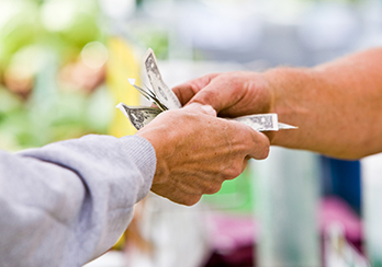  A man sitting at a kitchen/dining room table, typing on a laptop computer