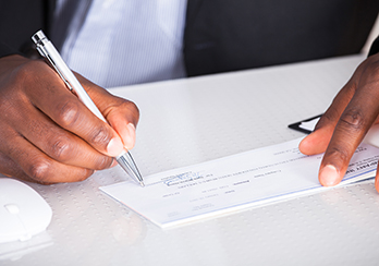 Hands, writing out a check or recording an amount in a check register