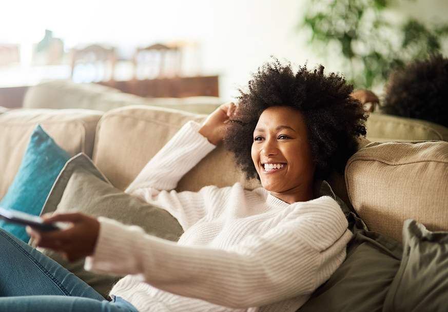 A smiling woman relaxing on a couch
