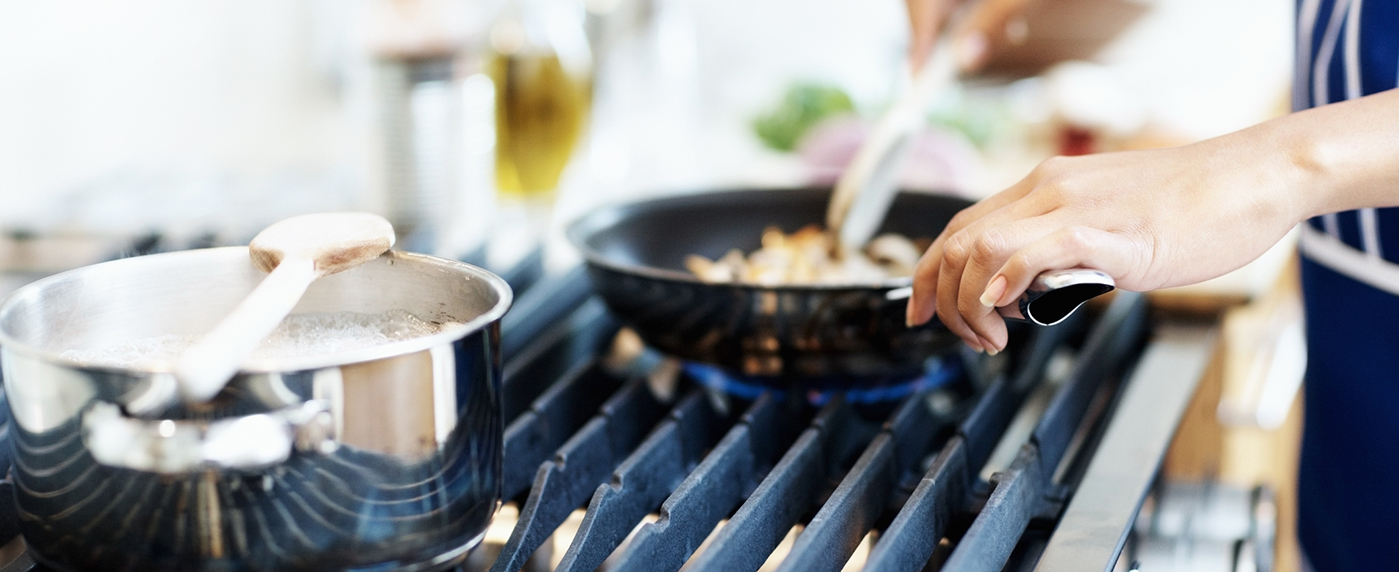 A person cooking on a gas stove