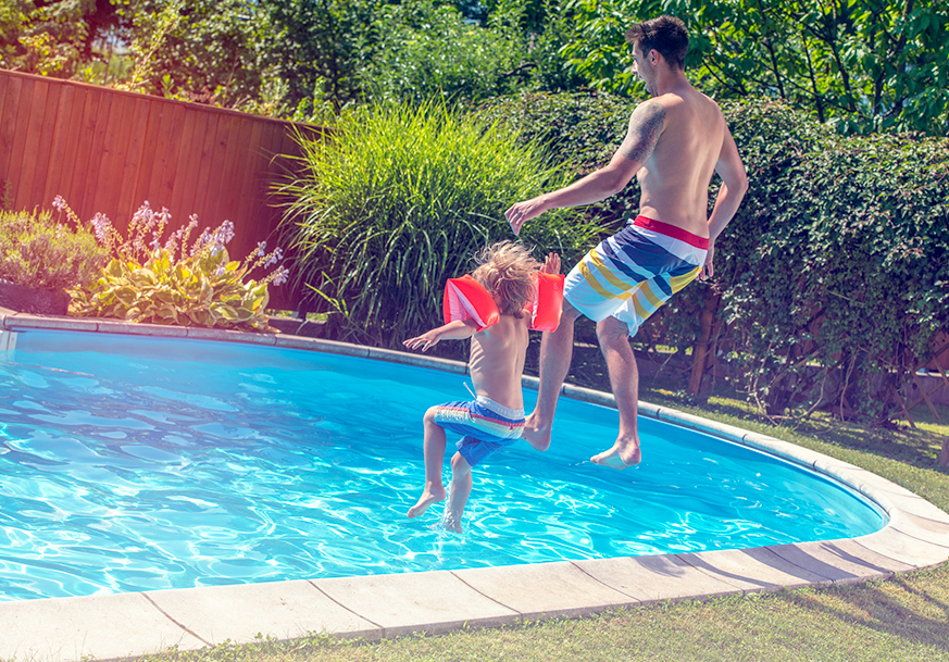 Two kids jumping into a swimming pool